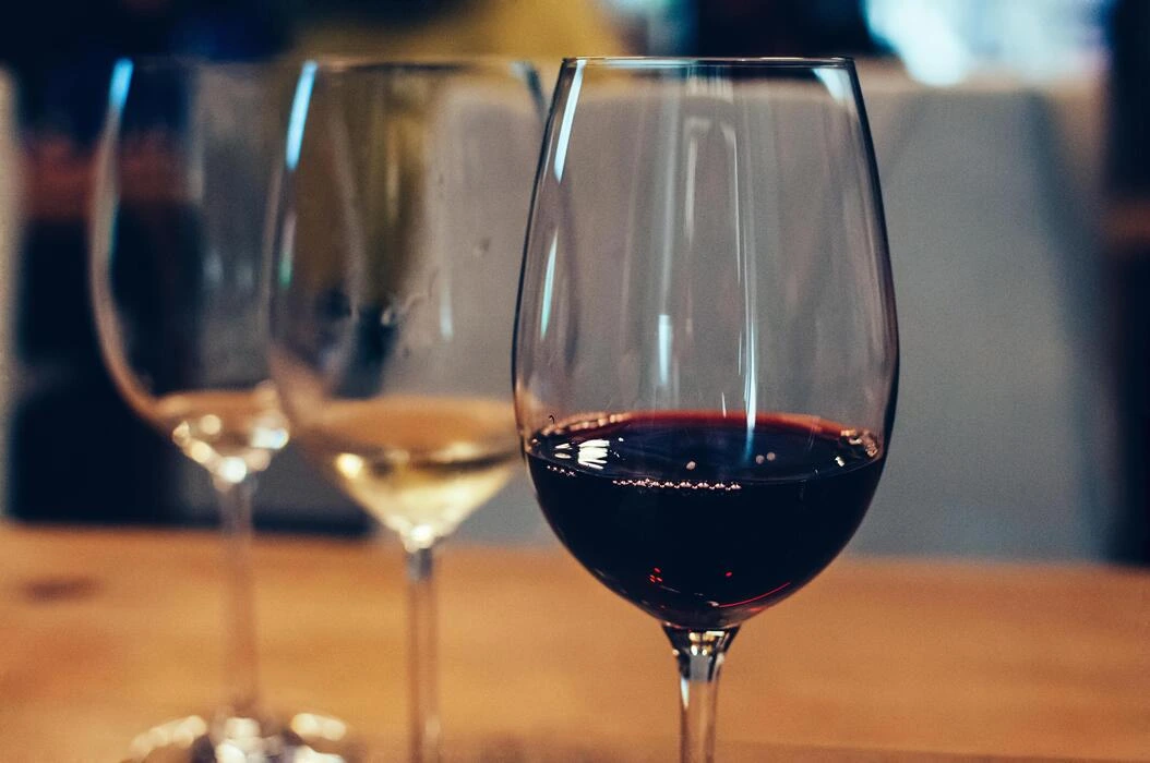 Bartender pouring red wine into a glass under warm ambient lighting